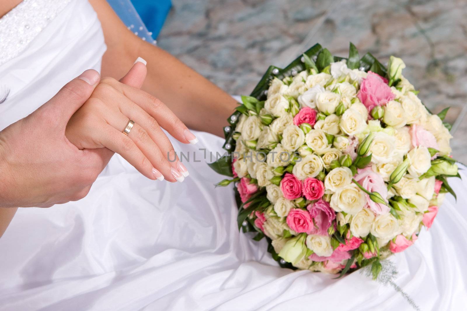 hands with gold rings, dress and flower bouquet