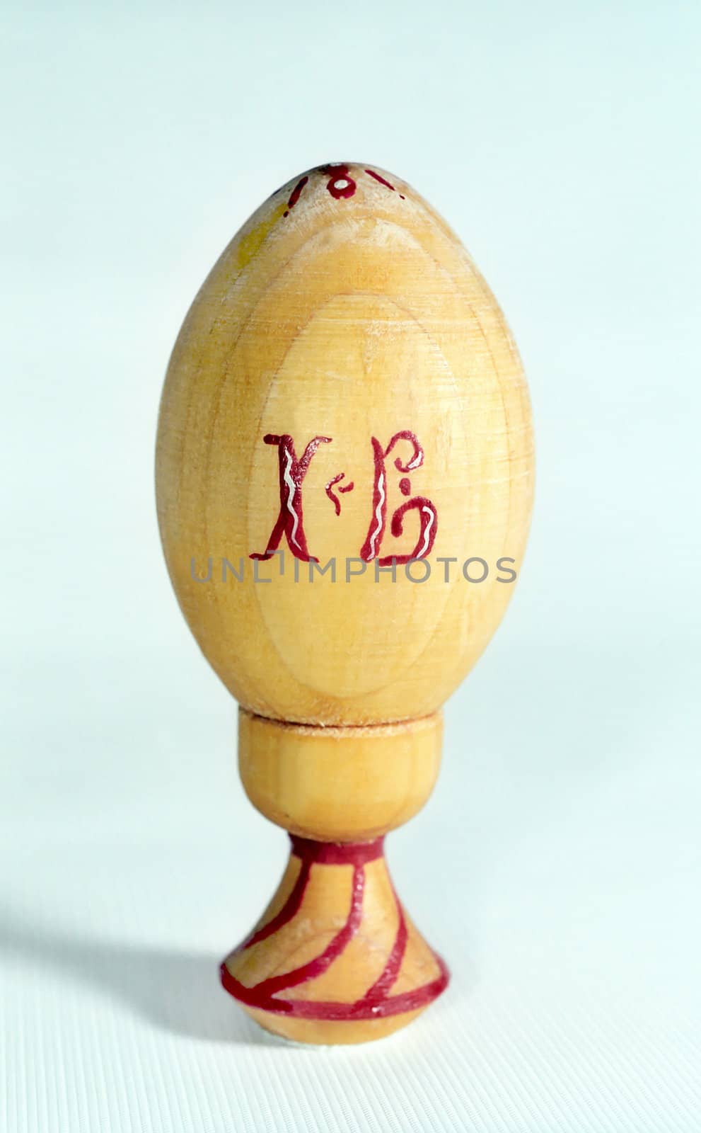 Easter egg of wood on the prop with red Slavic letters  