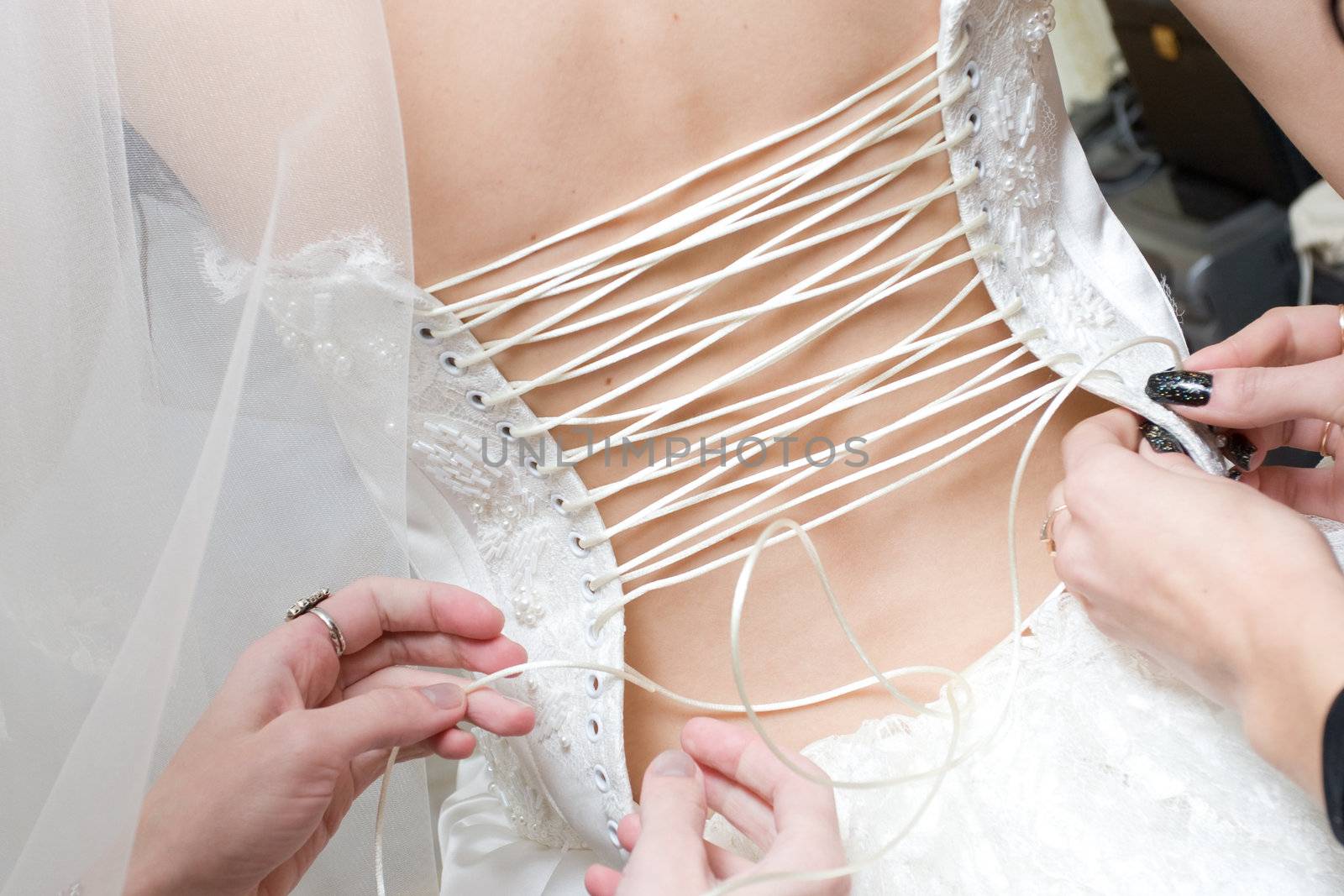 girls lace up a dress of the bride by vsurkov
