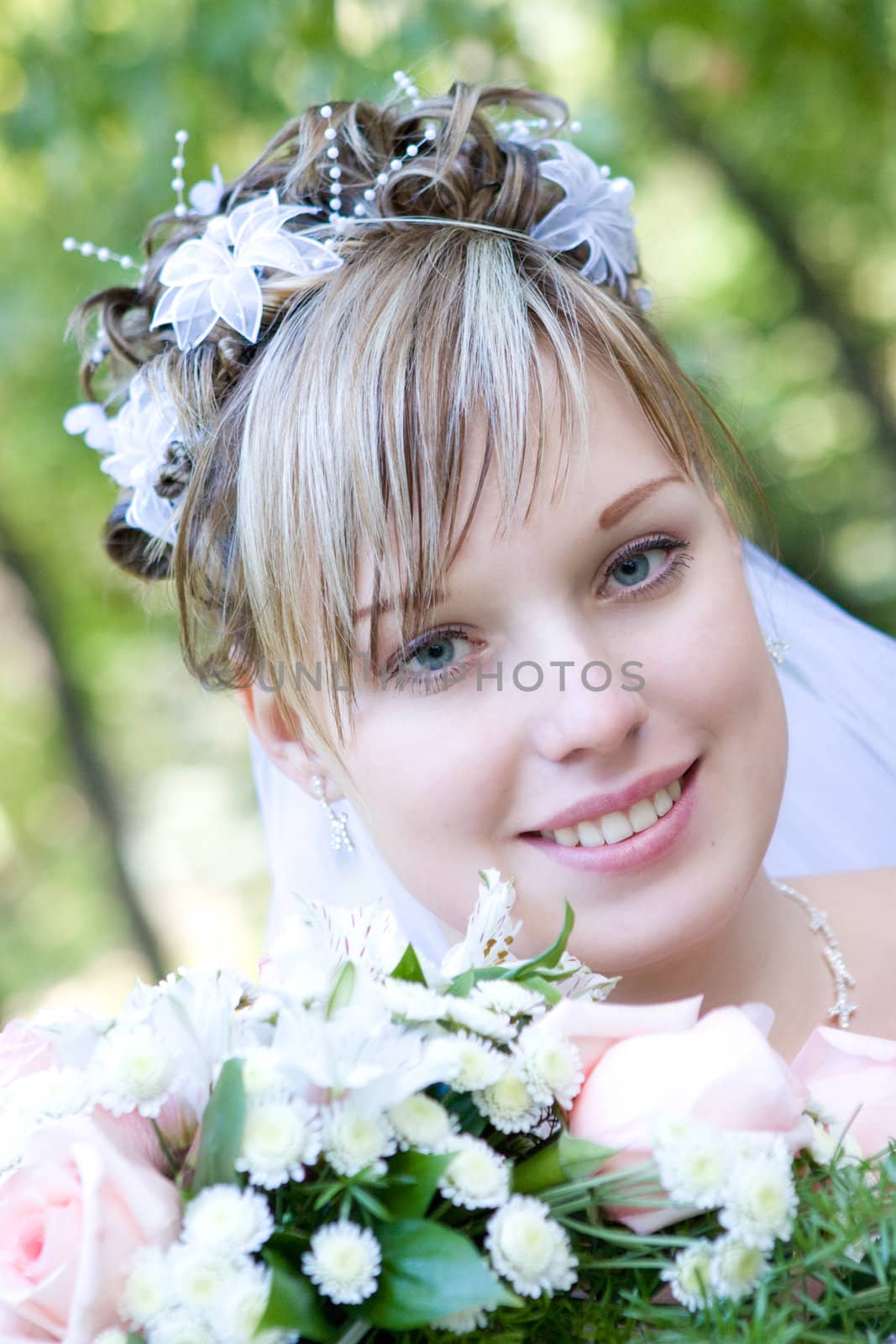 bride with a flower bouquet embraces a tree