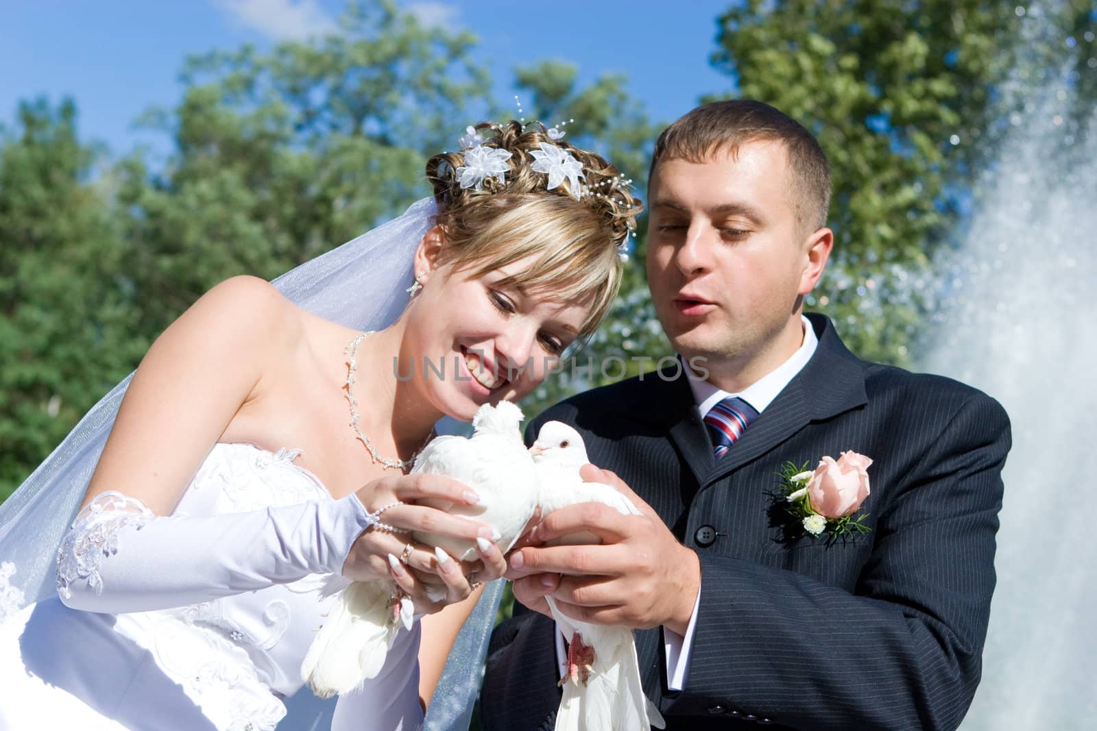 bride and groom with white pigeons in the hands