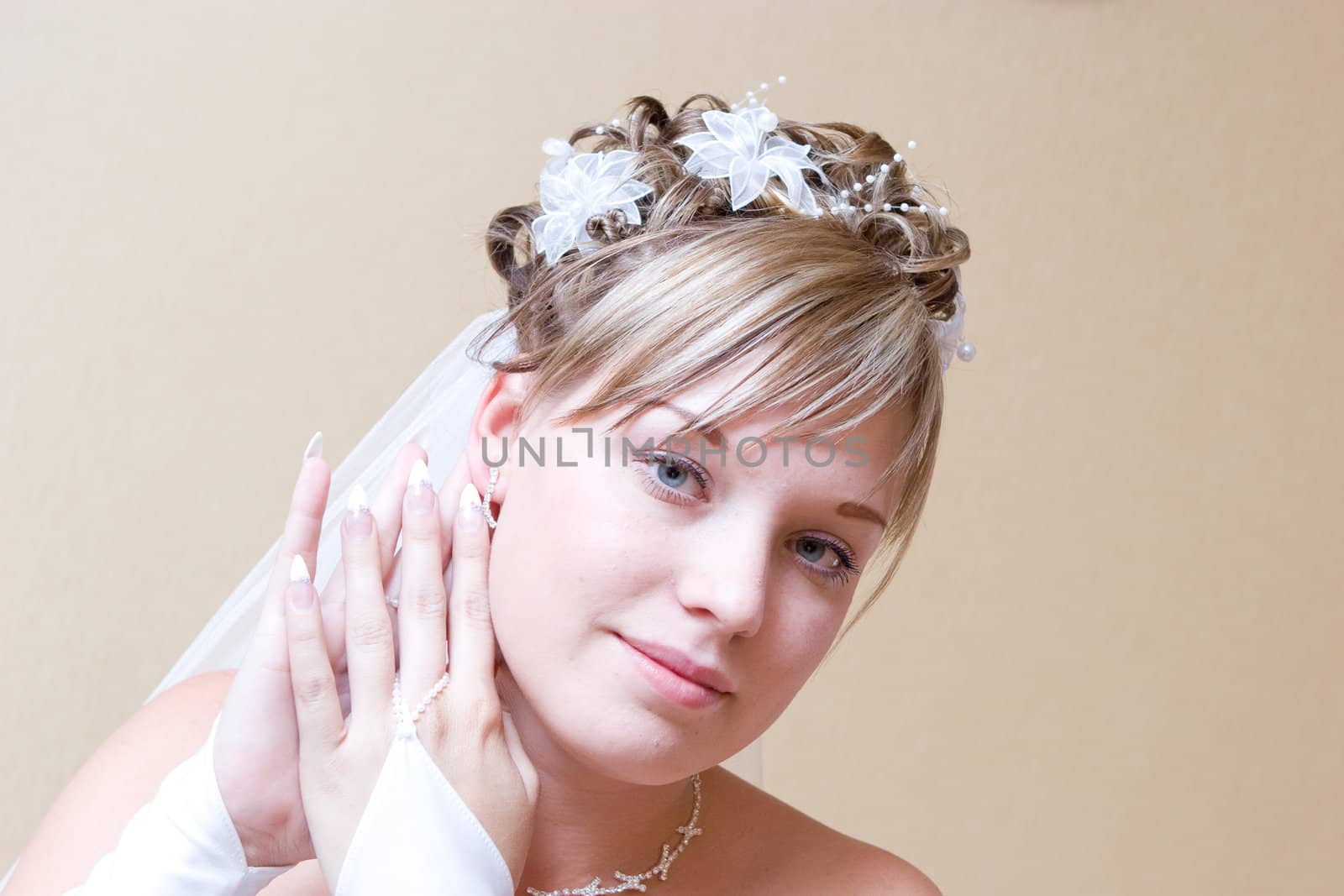 a beautiful bride carefully putting on ear-ring
