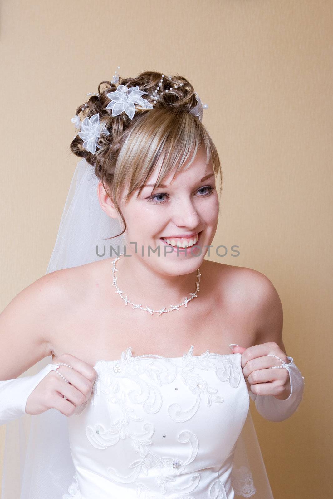 happy bride putting on wedding dress