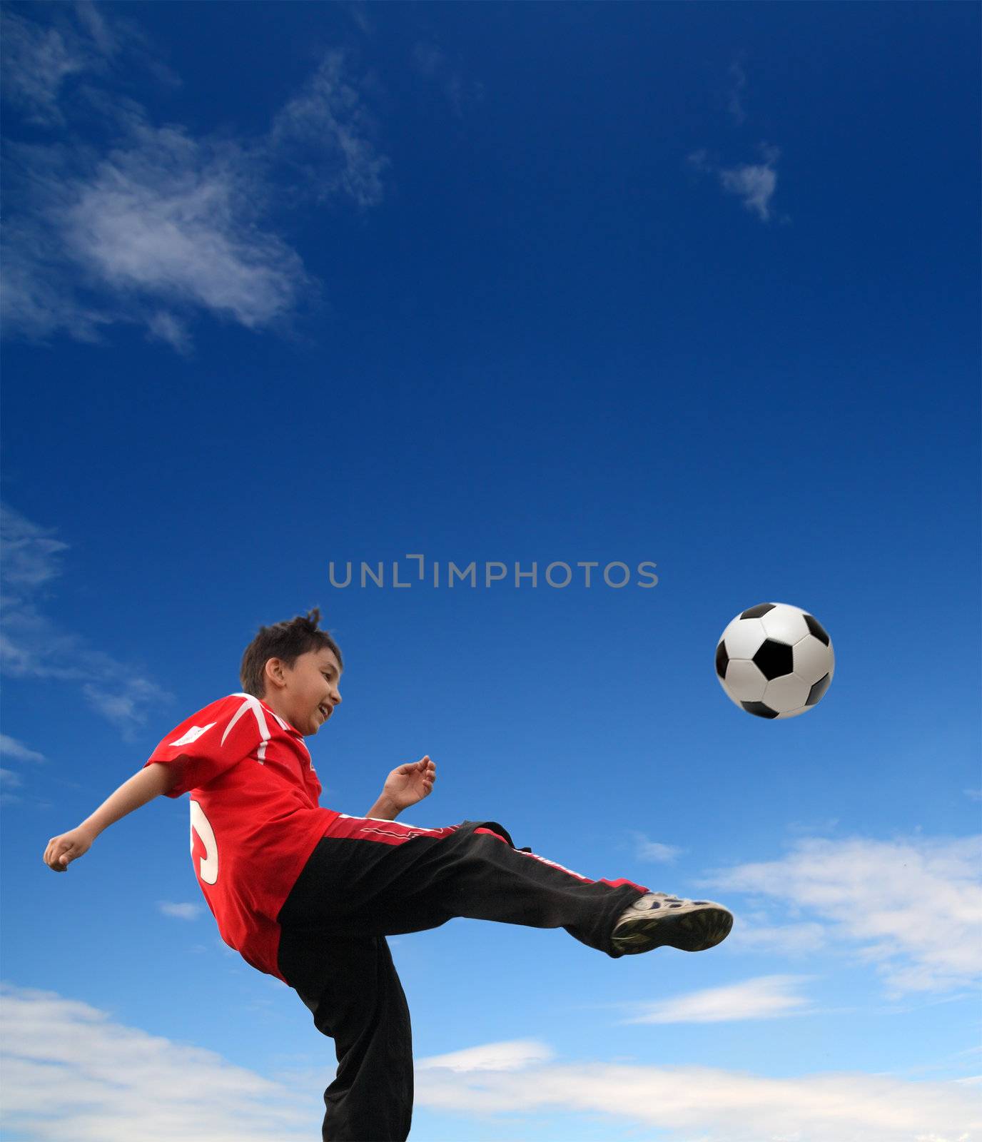 asian boy playing football under blue sky