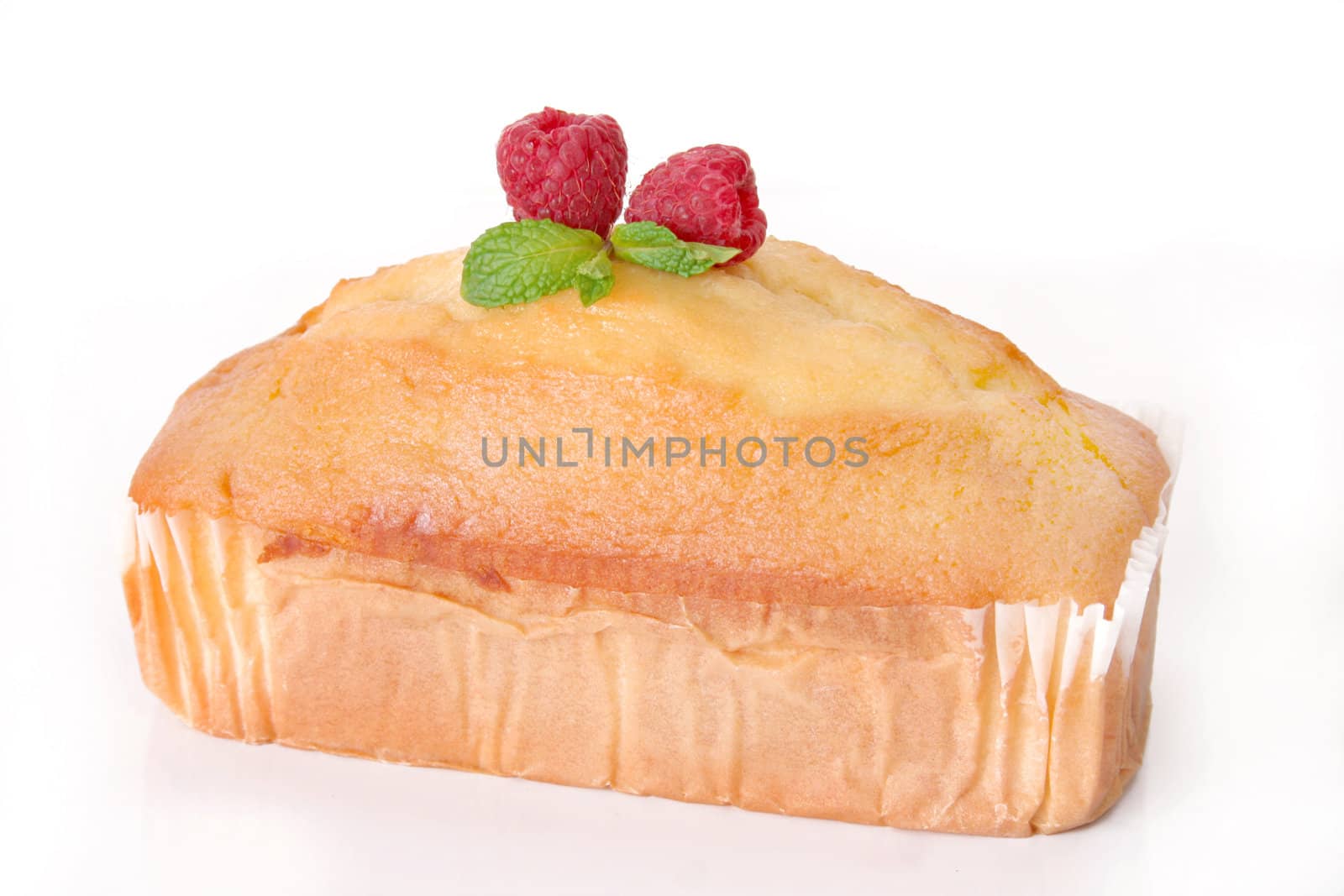 Delicious pound cake with raspberries and mint leaves as a garnish and shot on a white background.