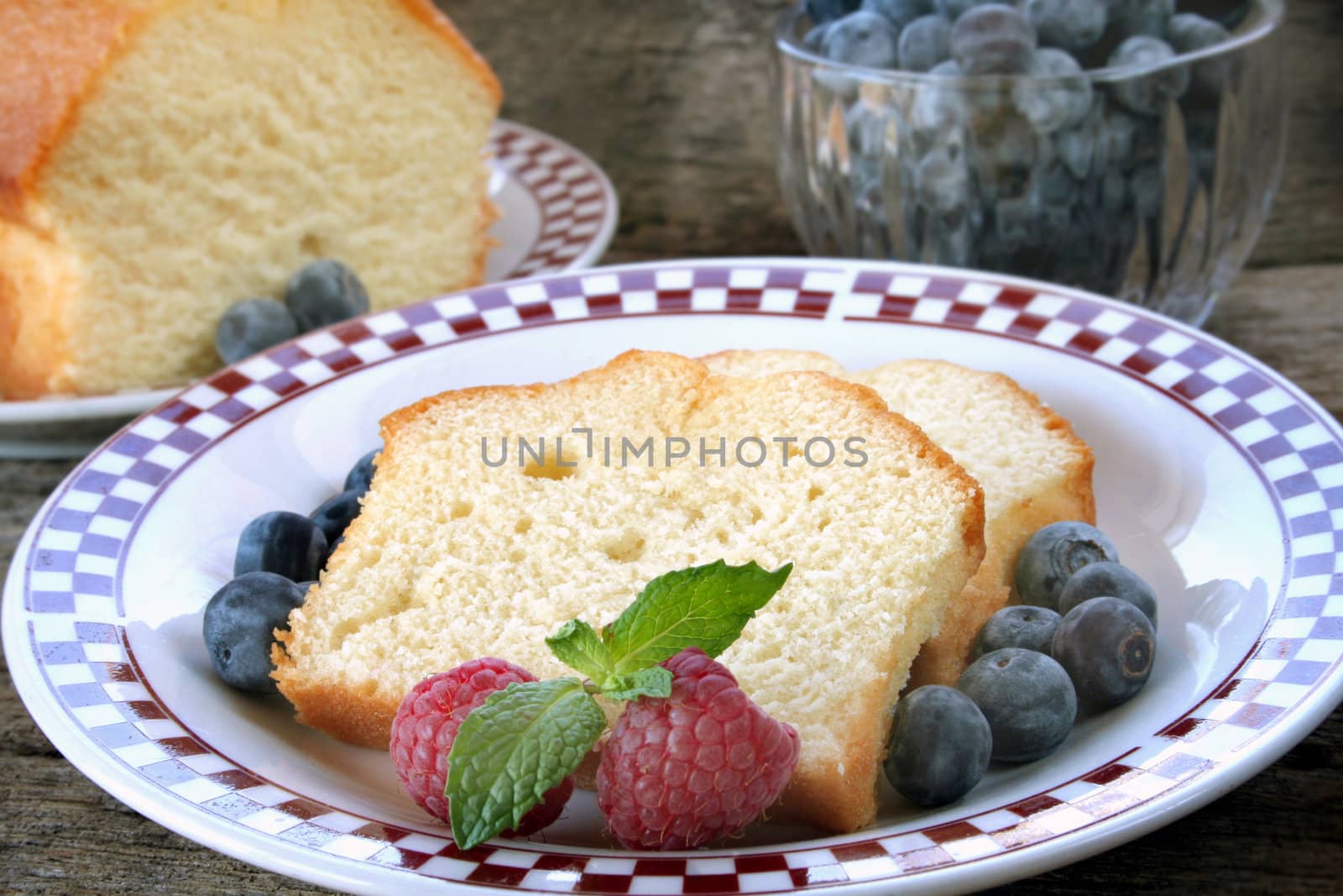 Slices of pound cake with fresh fruit served on a plate.