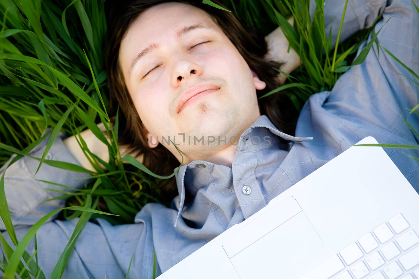 businessman rest on the grass with laptop