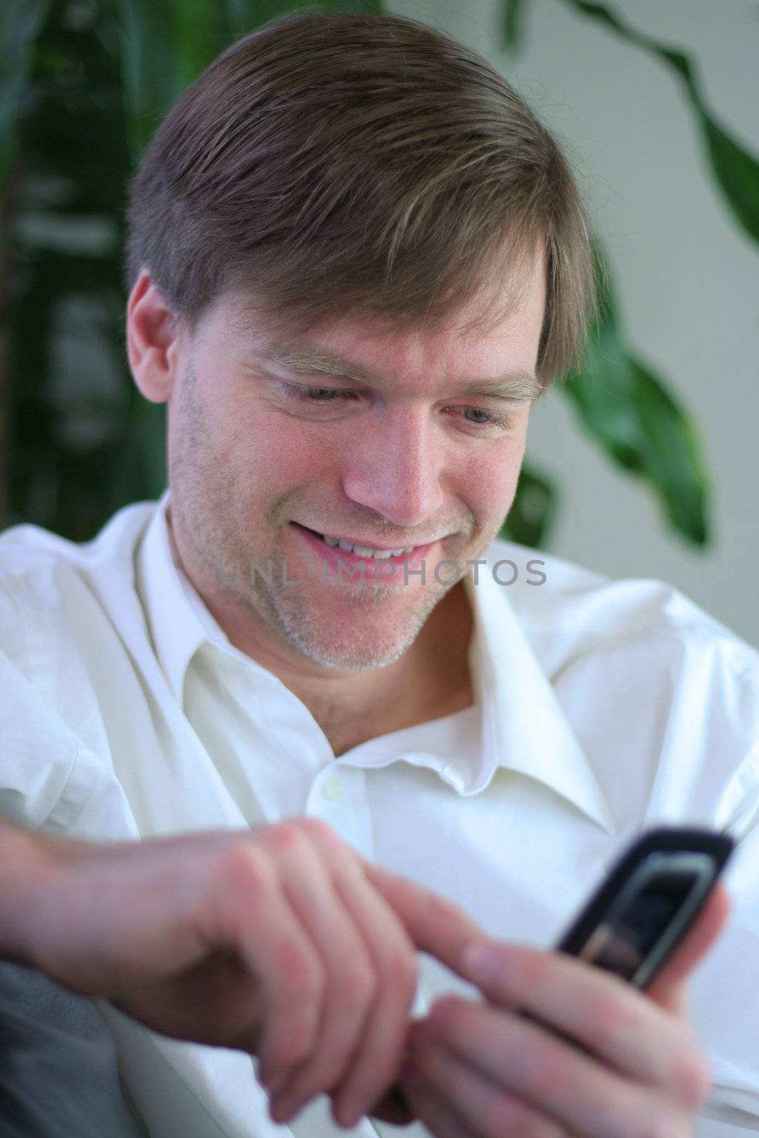 Handsome businessman using cell phone in casual attire.