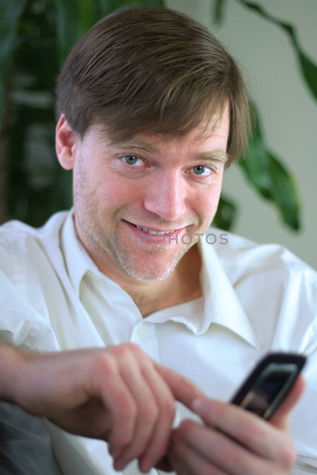 Handsome businessman using cell phone in casual attire.