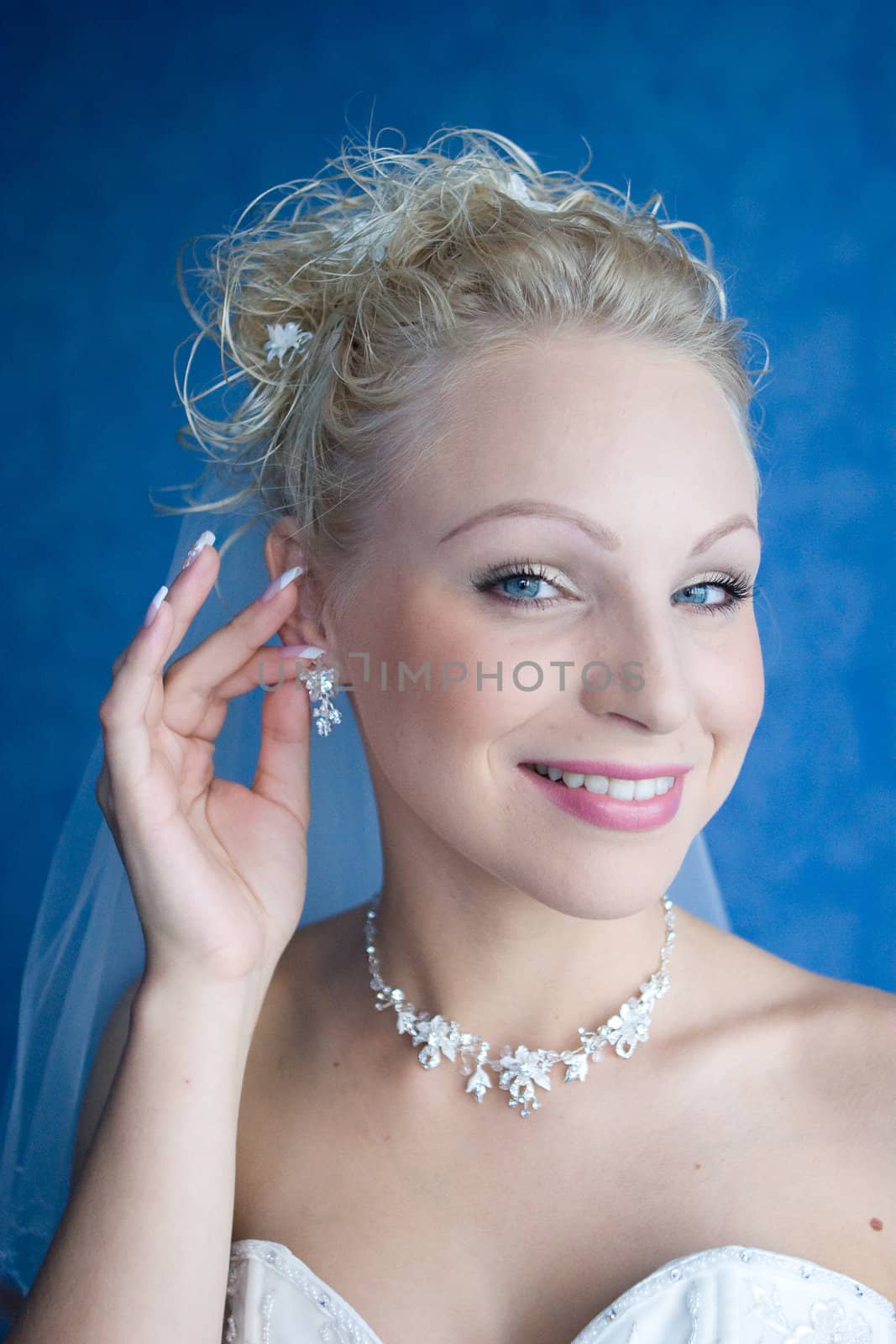 a happy bride puts on ear-rings