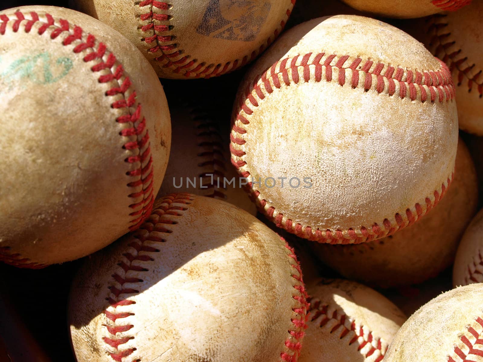 Old baseballs in a bucket after long season