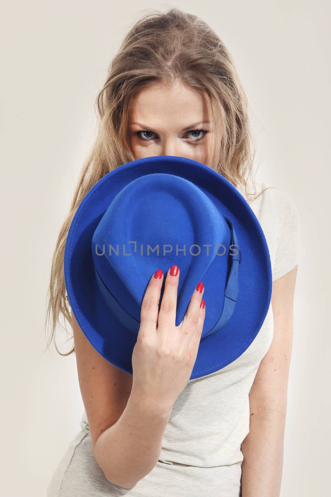 Beautiful girl holding a blue hat by robert_przybysz