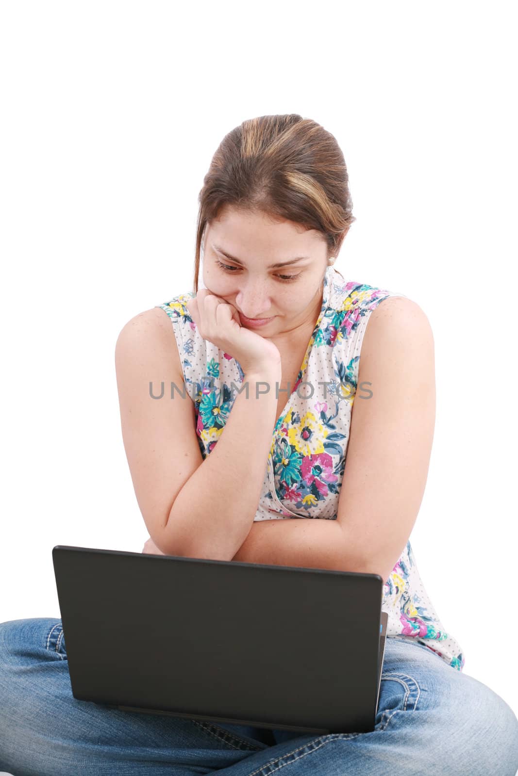 Beautiful young woman sitting on floor with a laptop, isolated on white