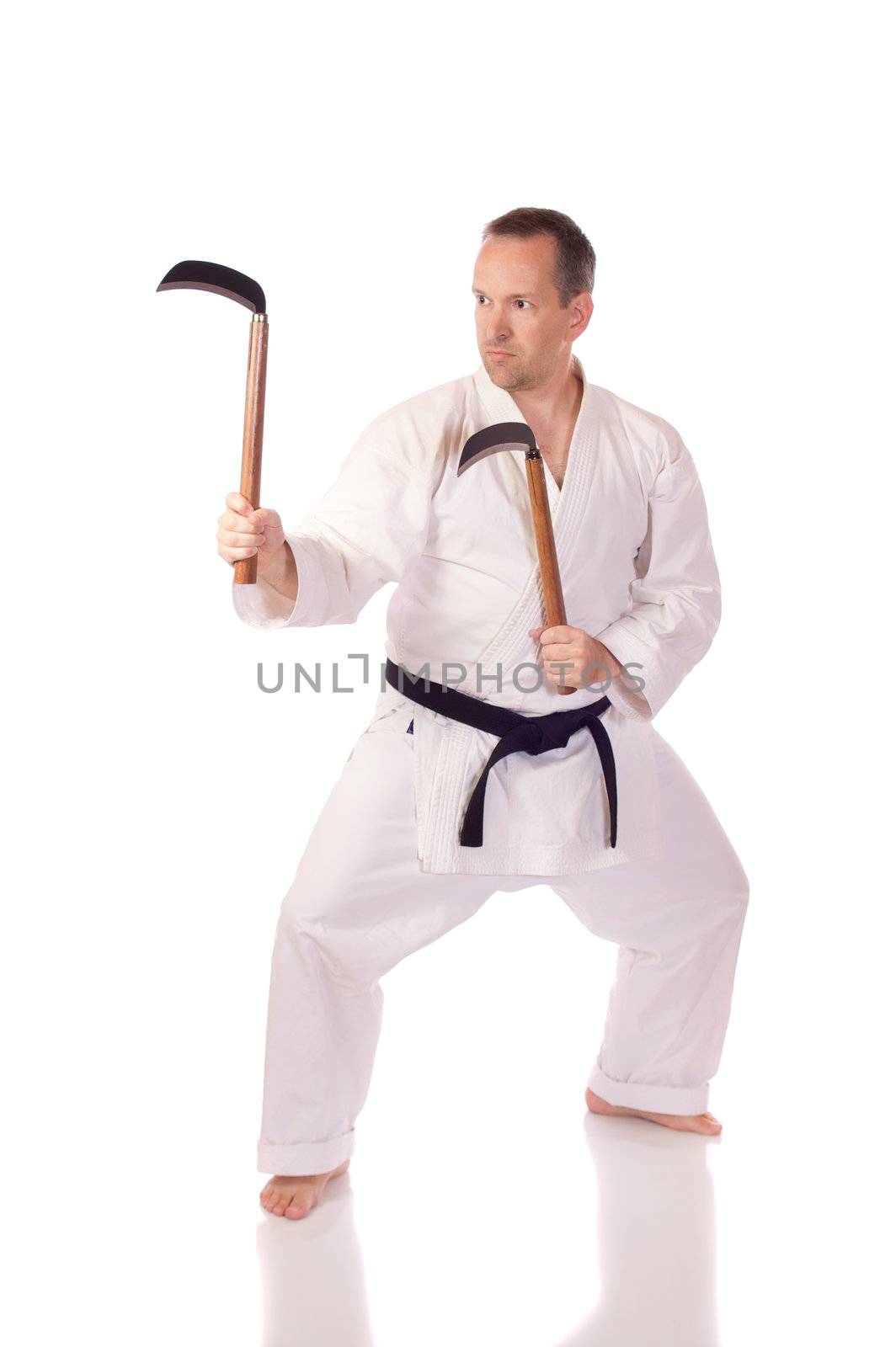 Man in karate-gi with two kama in his hands