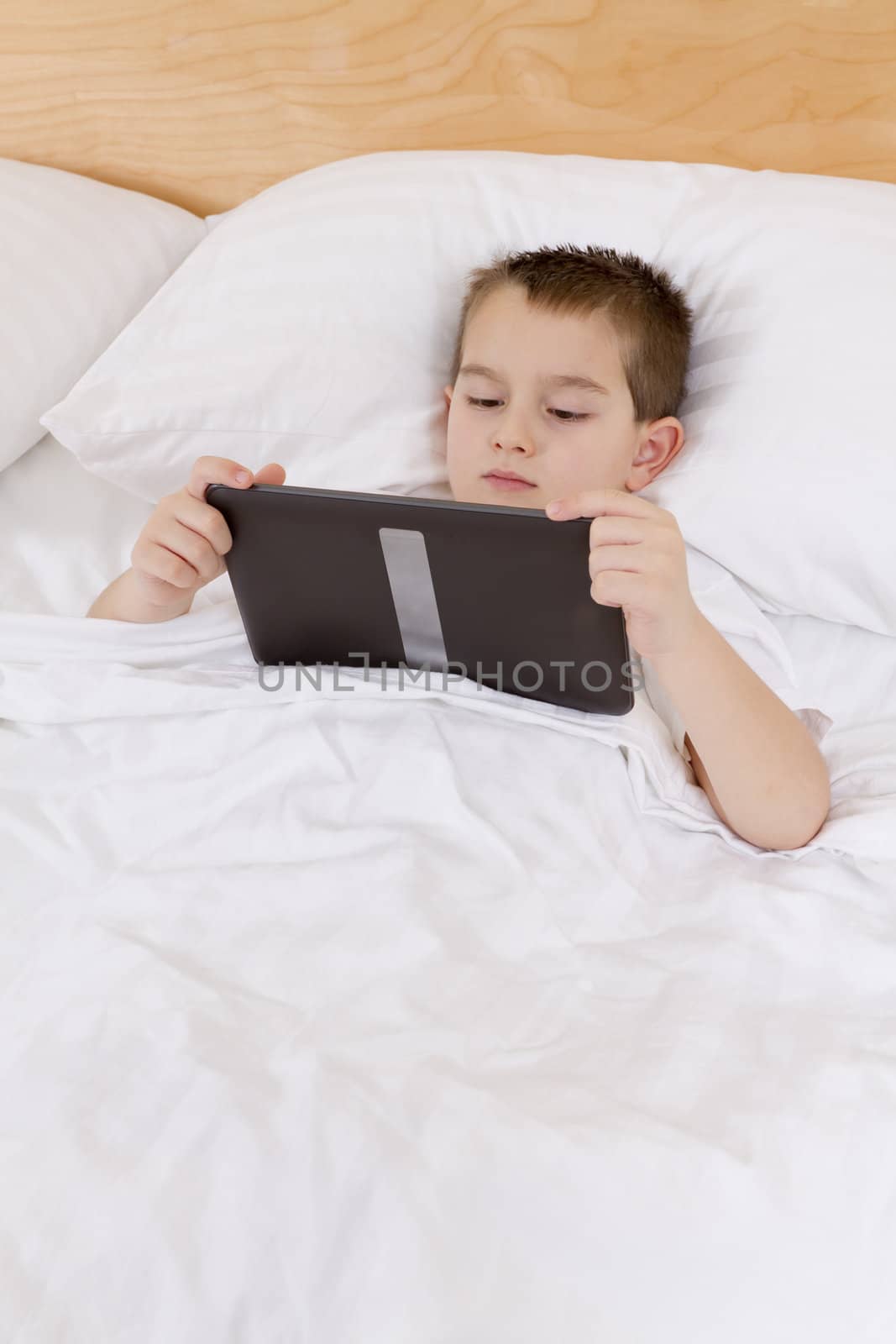First grade kid completing his bed time reading on his tablet.