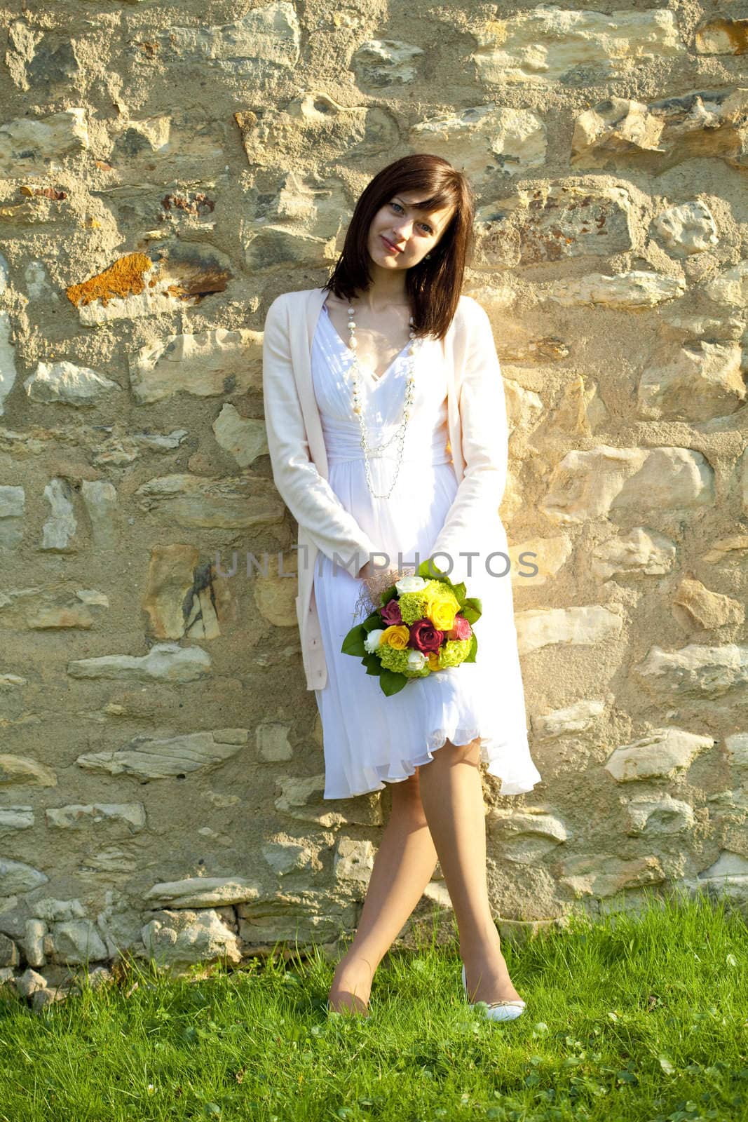young bride standing at the wall