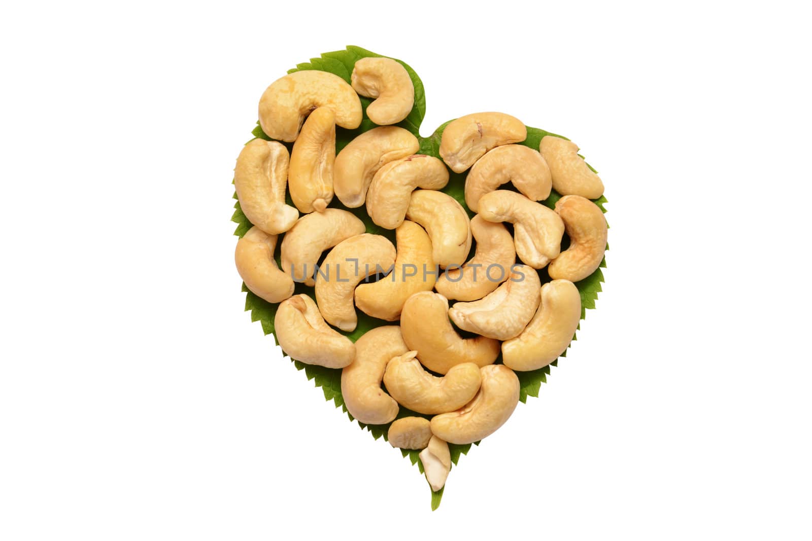 Ripe cashew nuts with leaves on a white background