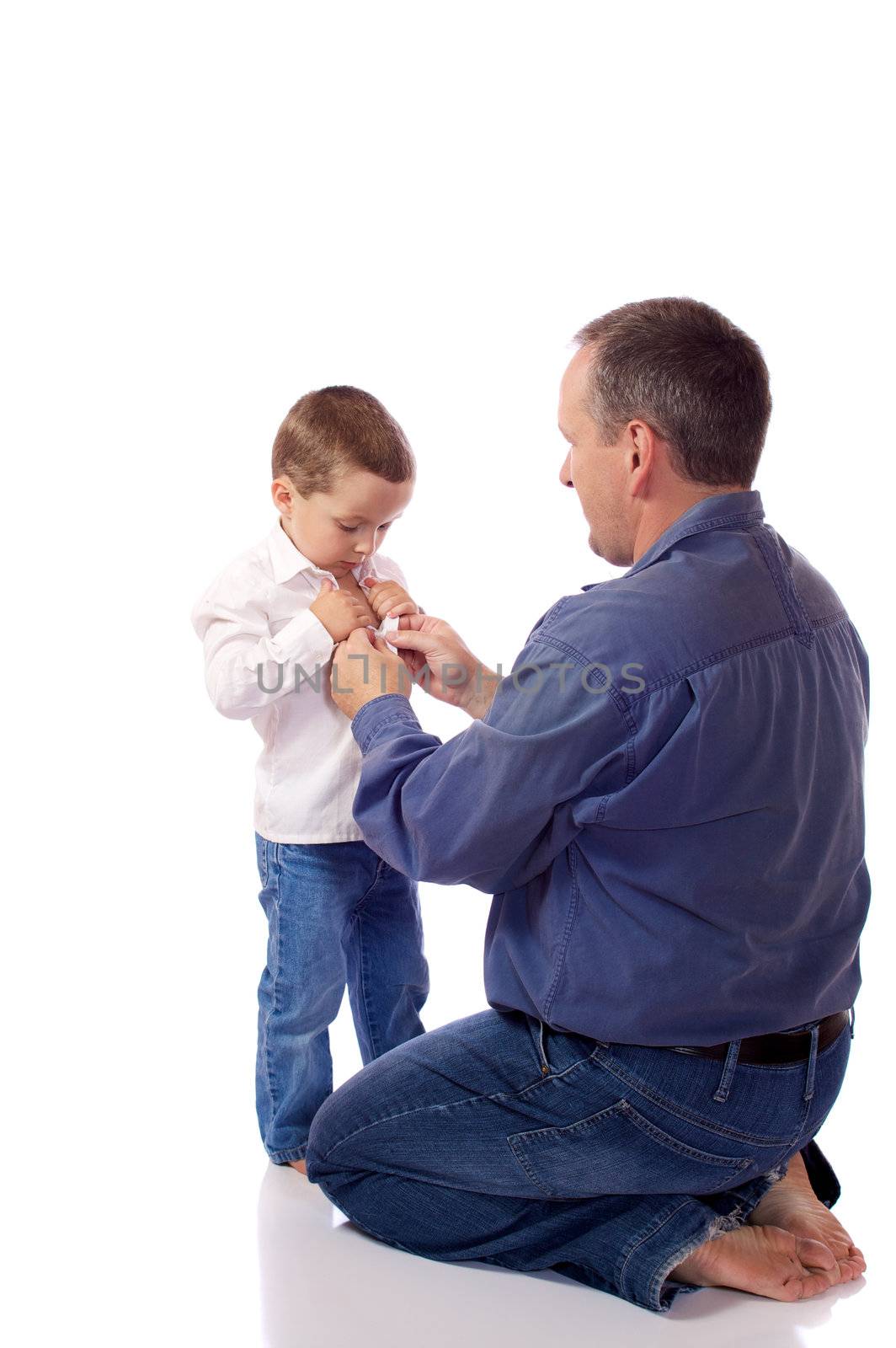 Father helping his son fastening his shirt buttons