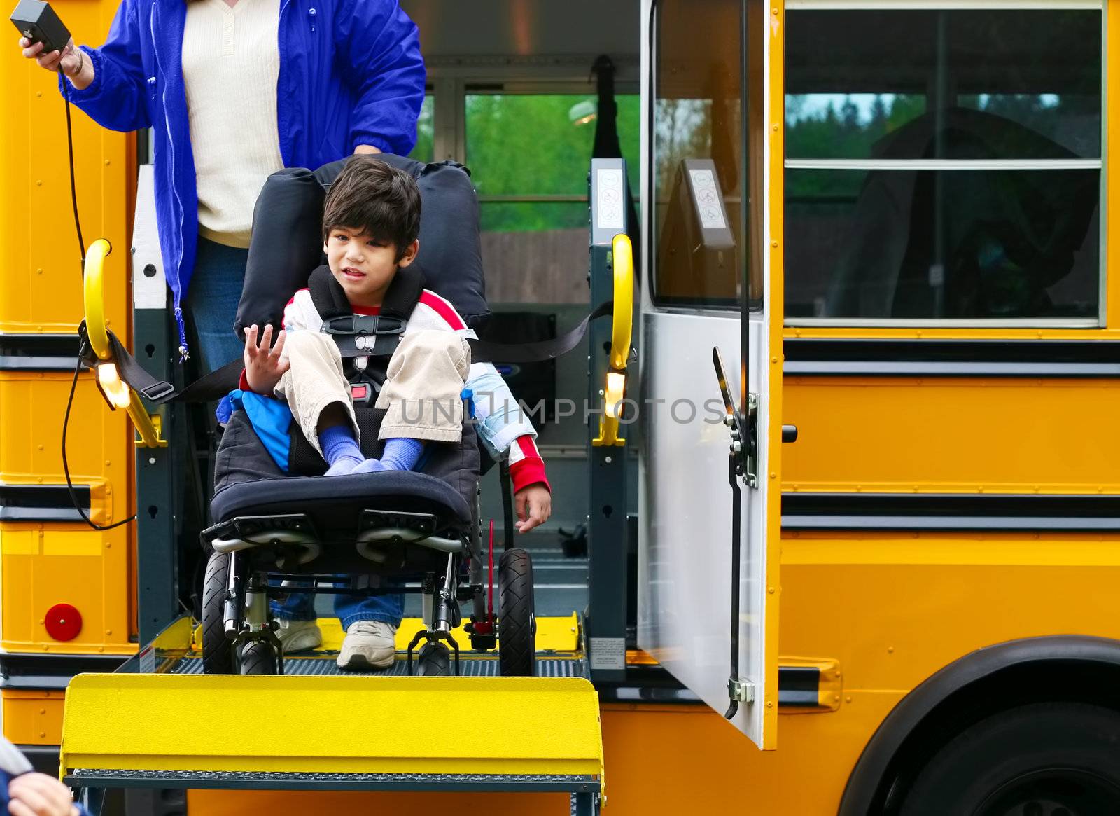 Disabled five year old boy using a bus lift for his wheelchair