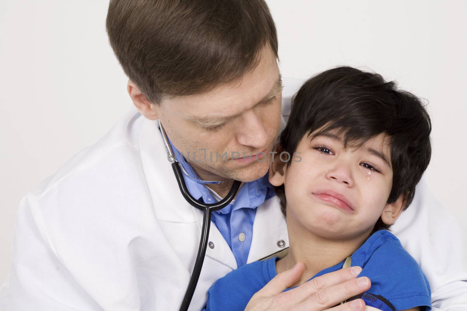 Male doctor comforting scared  toddler patient. Child is disabled with cerebral palsy. by jarenwicklund