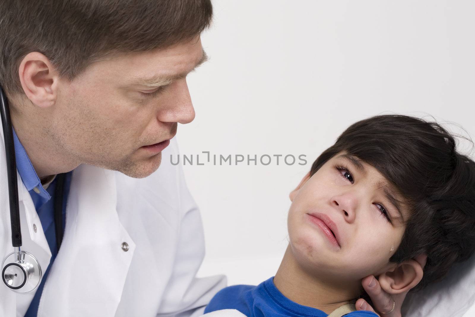 Male doctor in early forties comforting five year old disabled patient during office visit