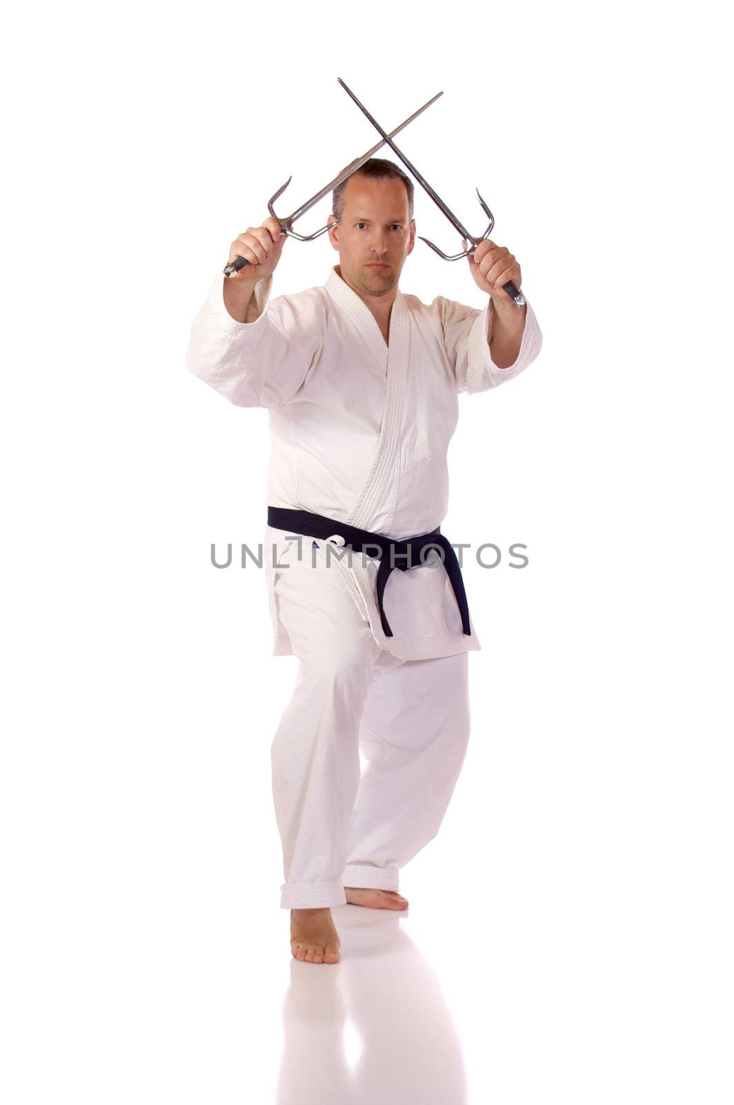 Man in karate-gi holding a pair of sai