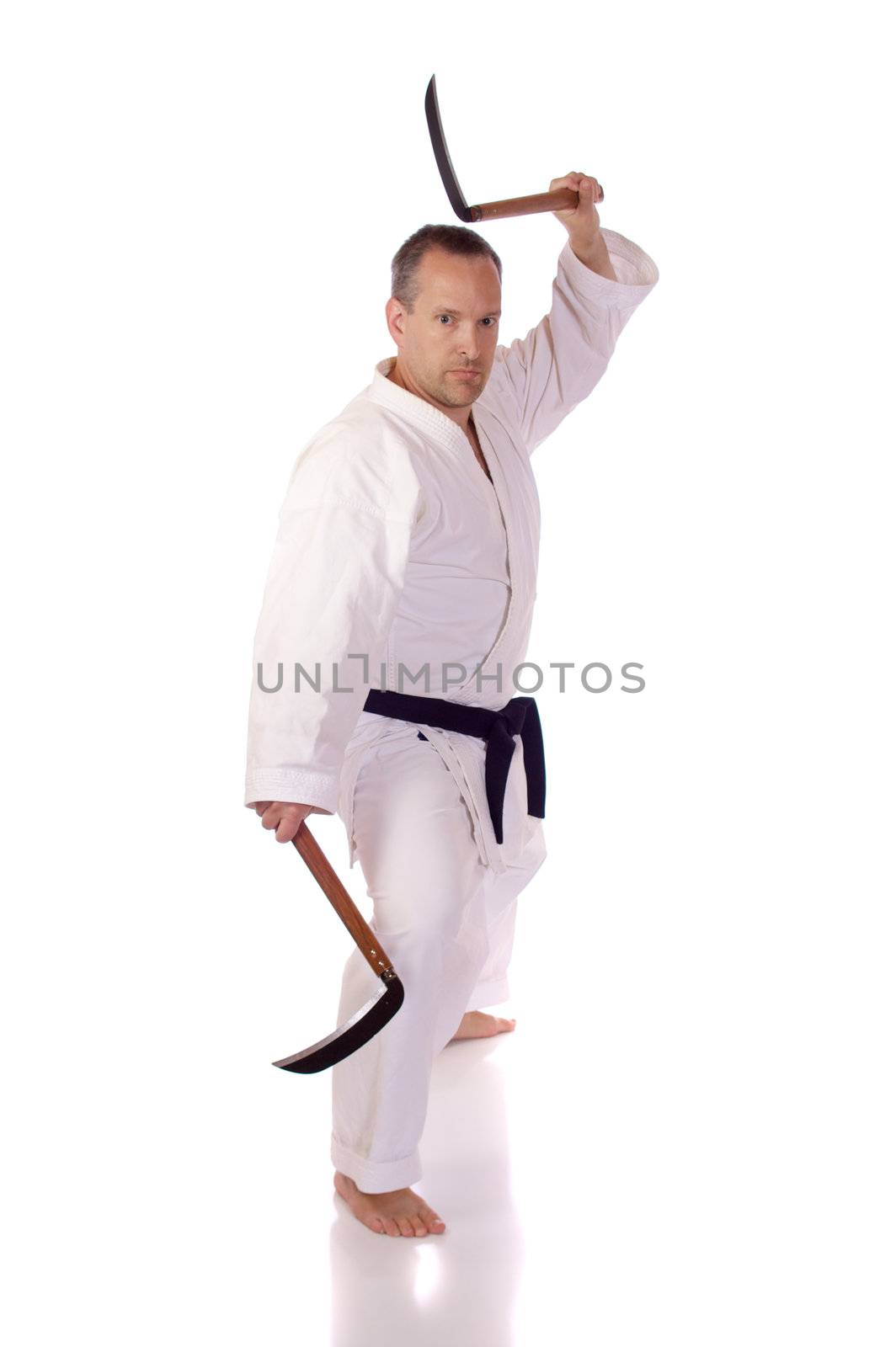 Man in karate-gi holding a pair of kama