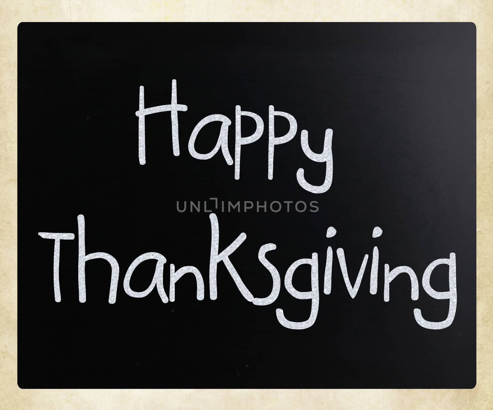 "Happy Thanksgiving" handwritten with white chalk on a blackboard