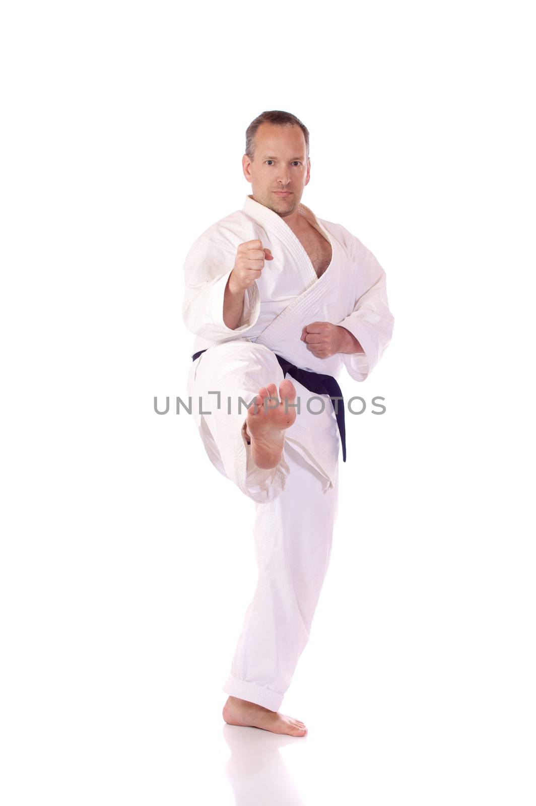 Man in karate-gi doing a front kick