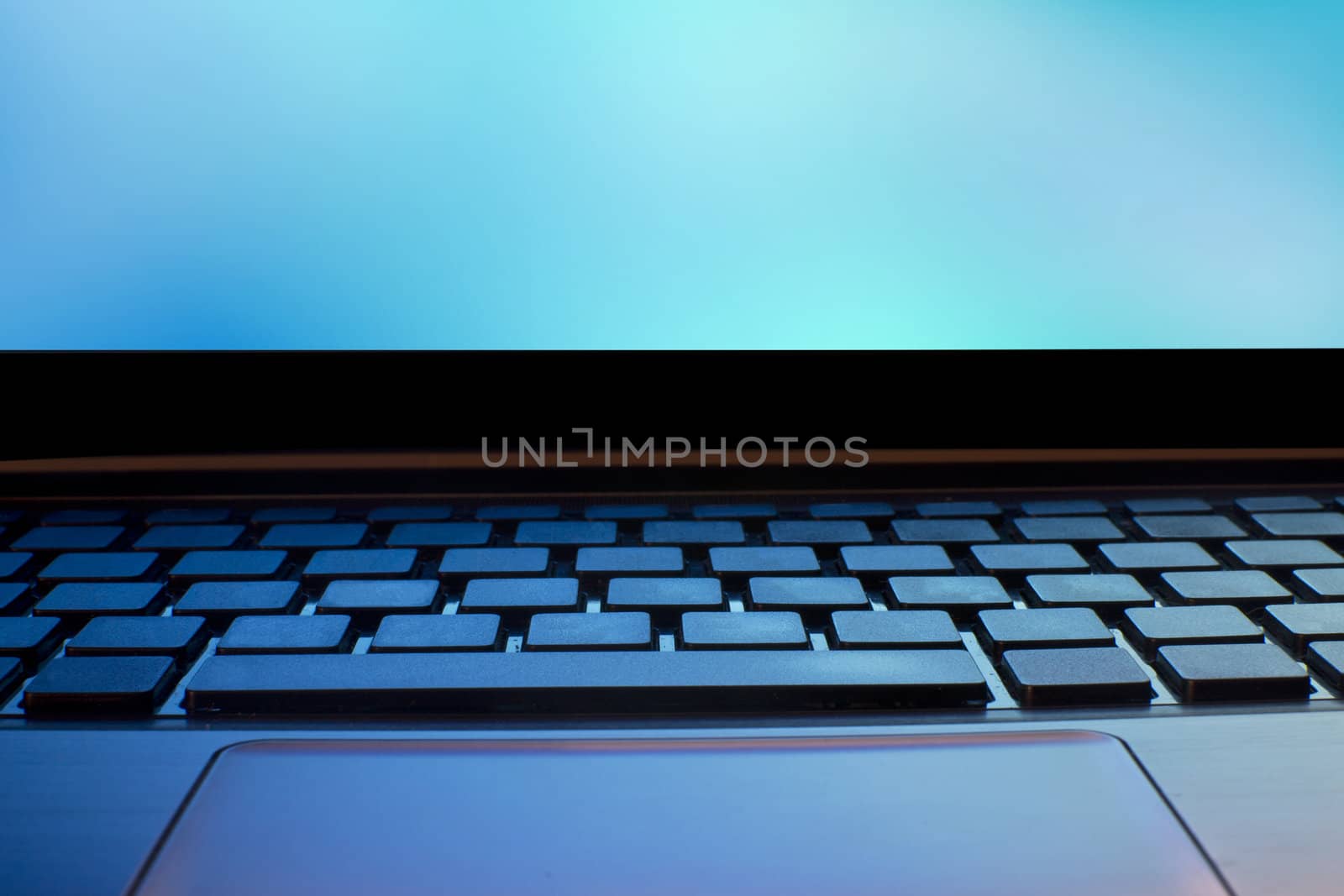 close up of laptop keyboard as a background toned to blue 