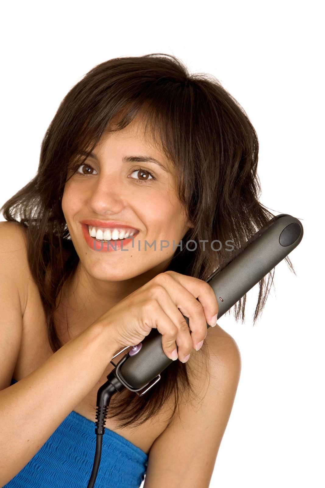 Portrait of beautiful woman using hair straighteners