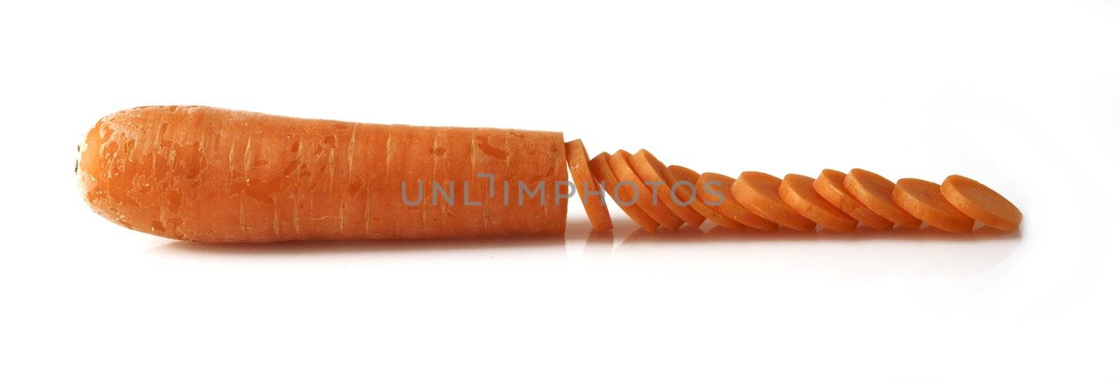 Closeup of partially sliced fresh organic carrot on white background