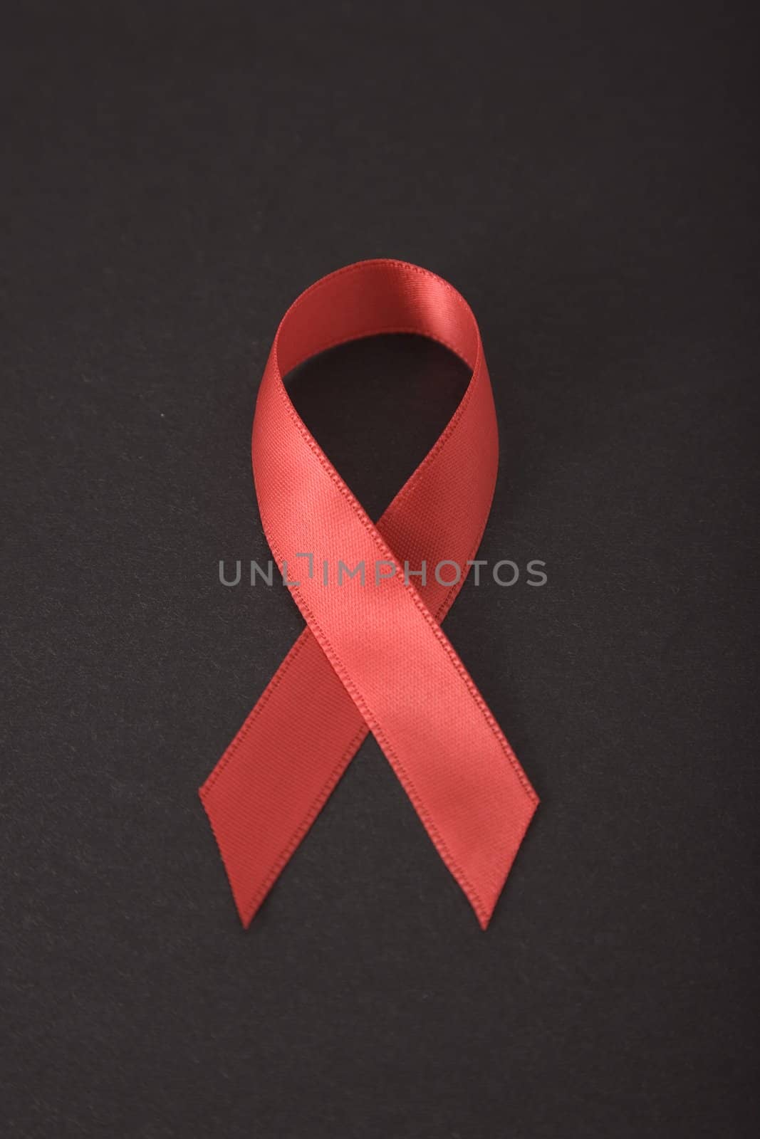Aids awareness red ribbon on black background