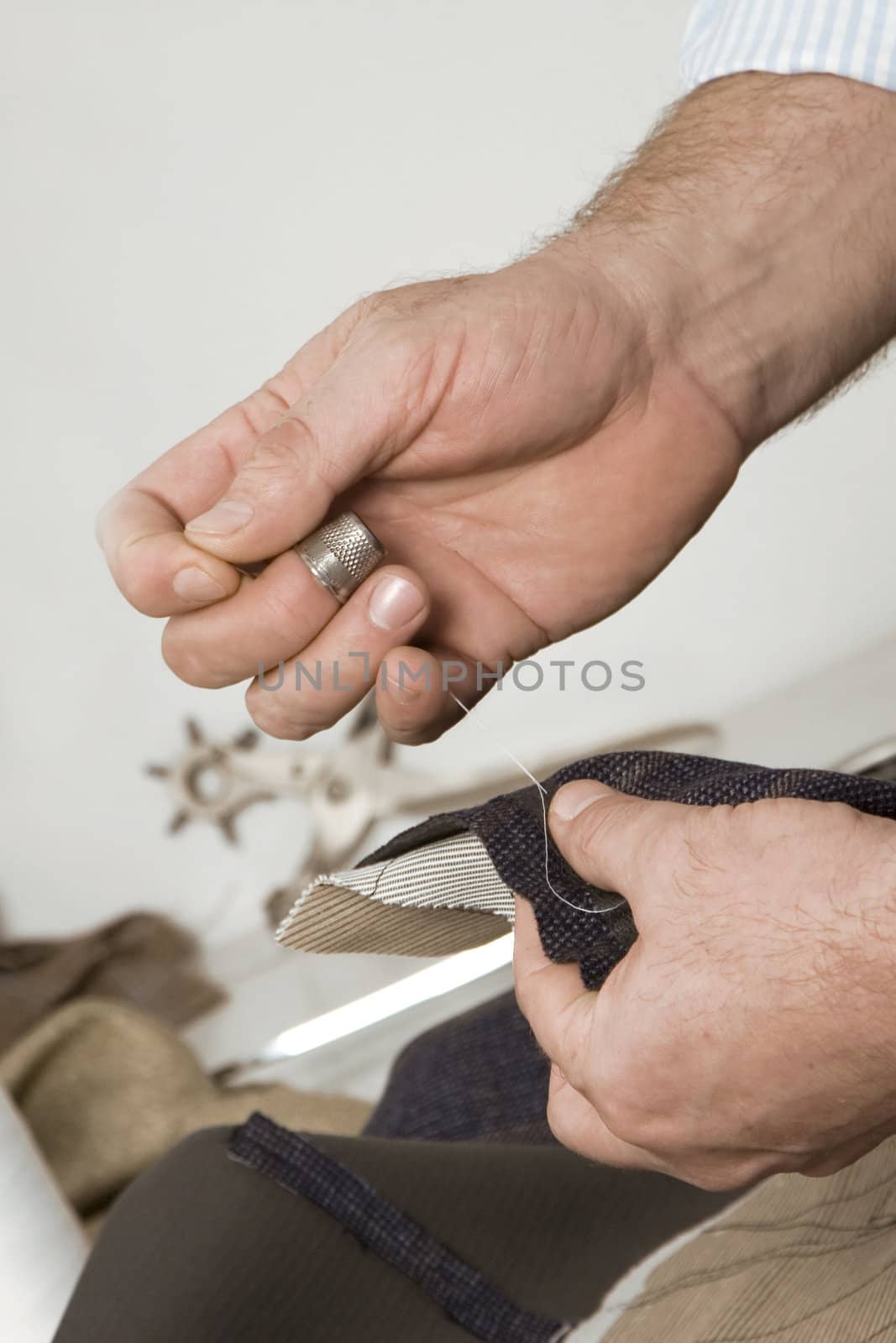 detail of sewing hand in tailor studio