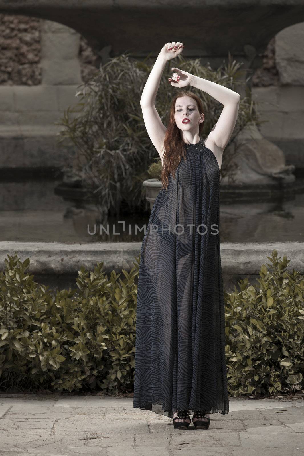 A beautiful young woman in a transparent dress in a garden