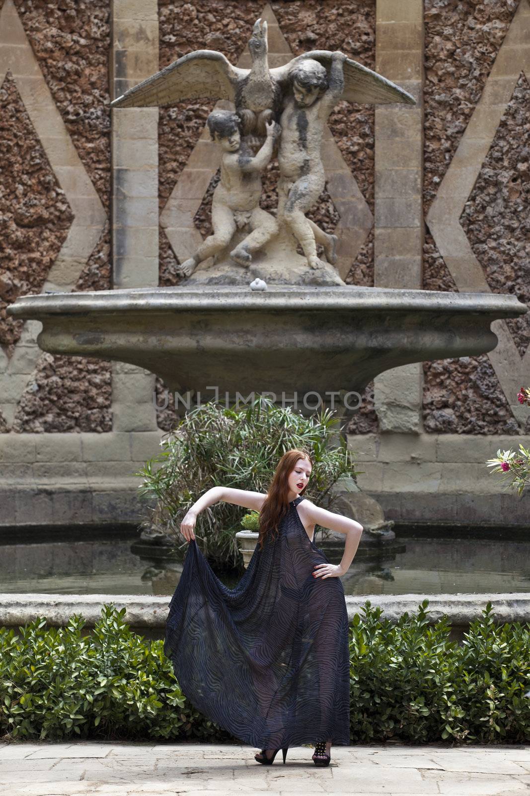 A beautiful young woman in a transparent dress in a garden