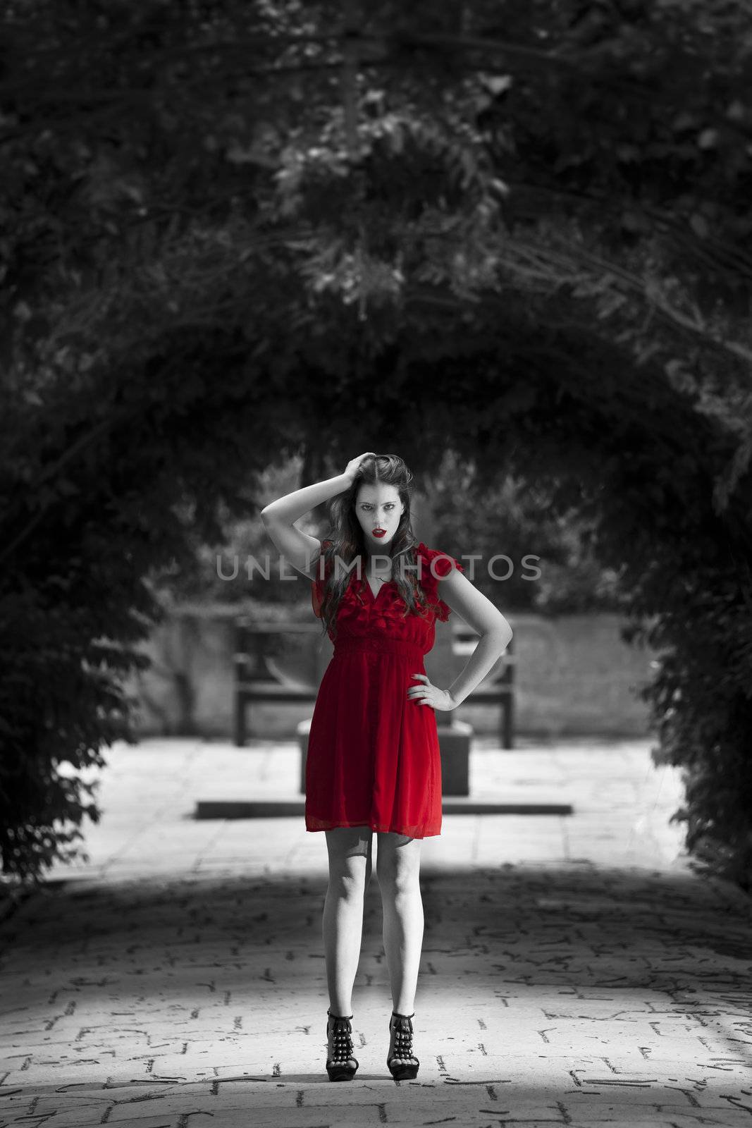 Monochrome image showing only red dress on a woman in almost intimidating stance
