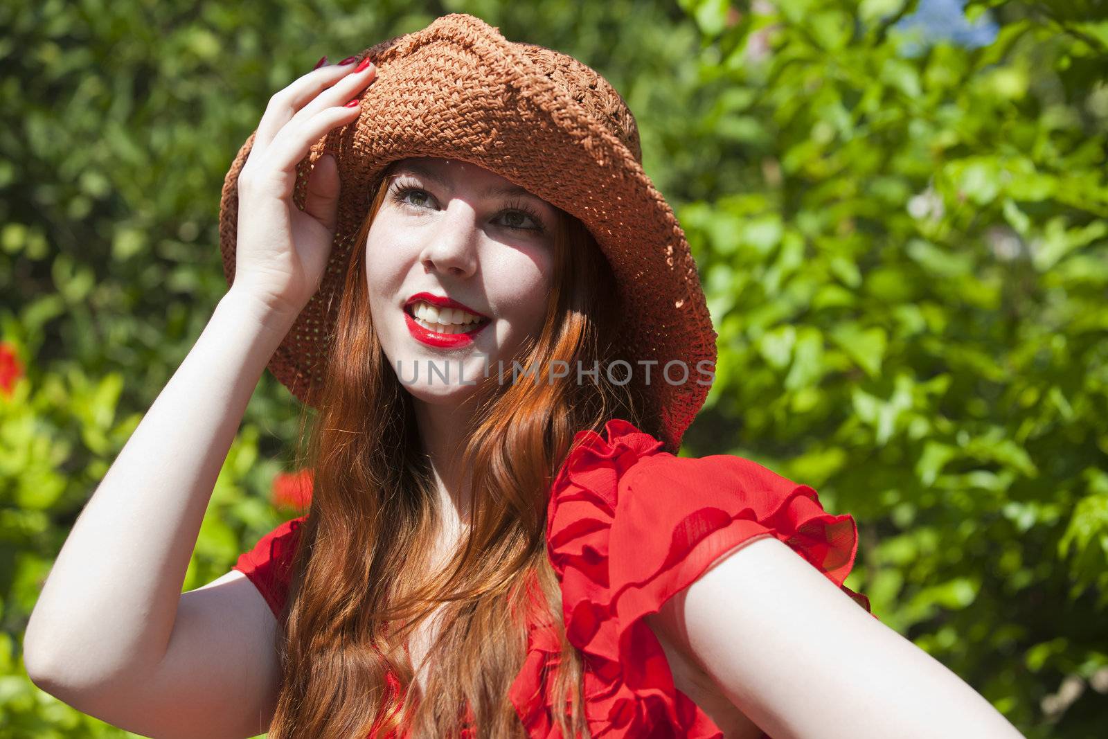 Young happy woman in red dress and hat
