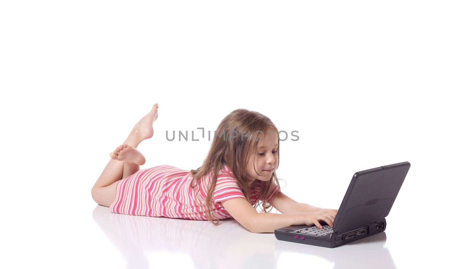 Cute little girl laying on her stomach with a laptop