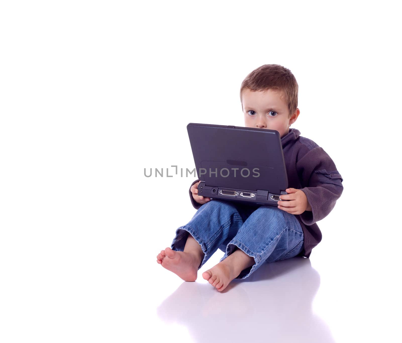 Cute little boy sitting with a laptop