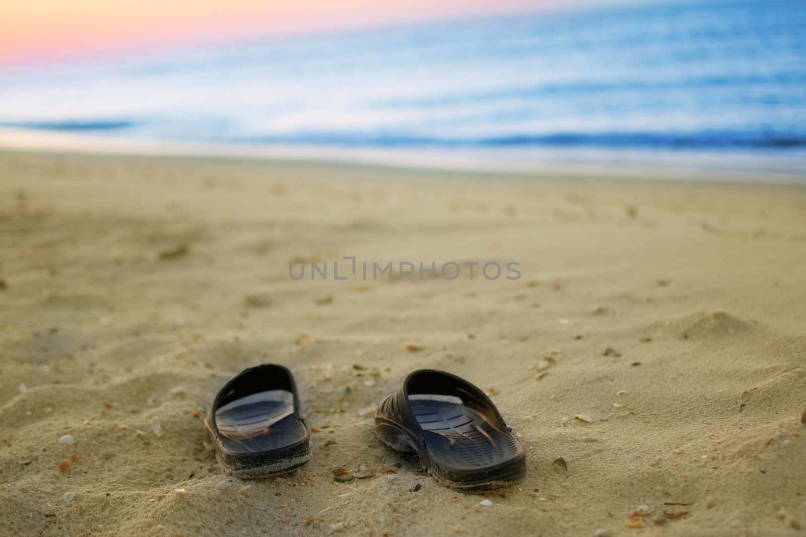 sneakers on a sandy beach  by Lexxizm