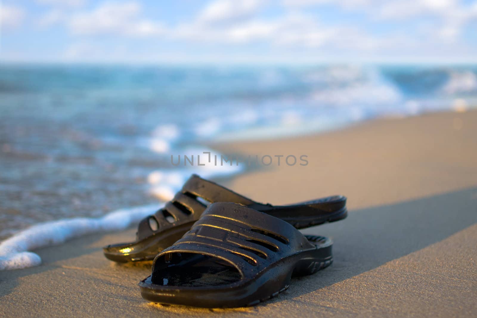 sneakers on a sandy beach  by Lexxizm