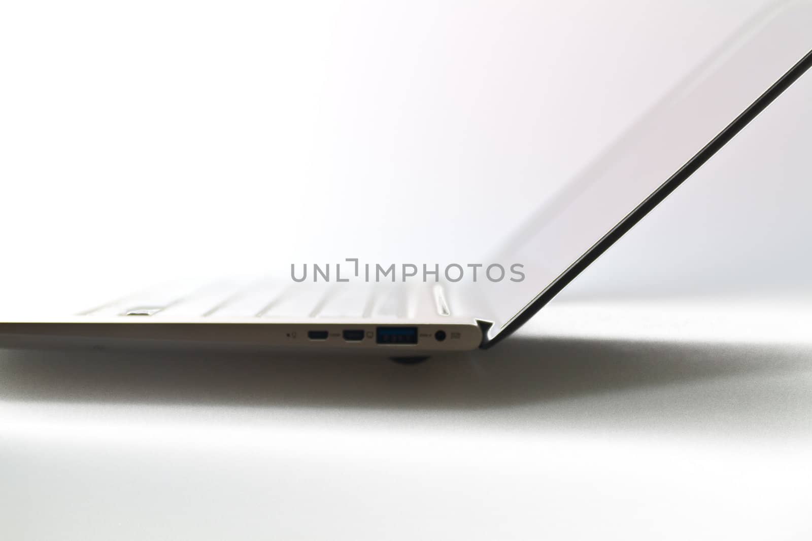a modern metal laptop with opened lid against white background for abstract background
