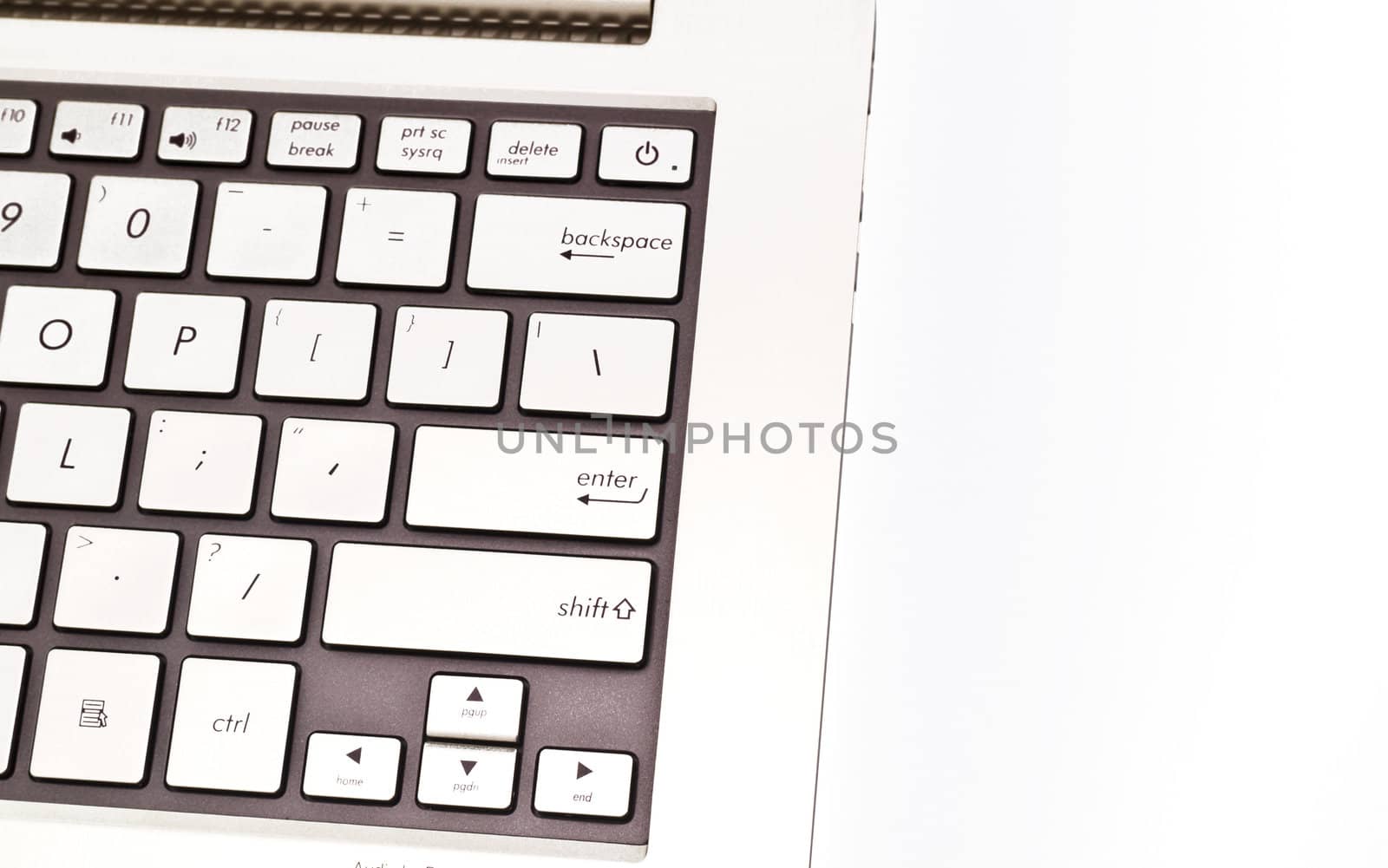 Angled view of a keyboardpad on a modern metal-finished laptop against white for abstract and background