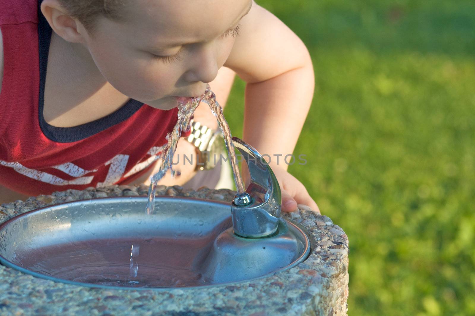 Small boy drinking from a fountain