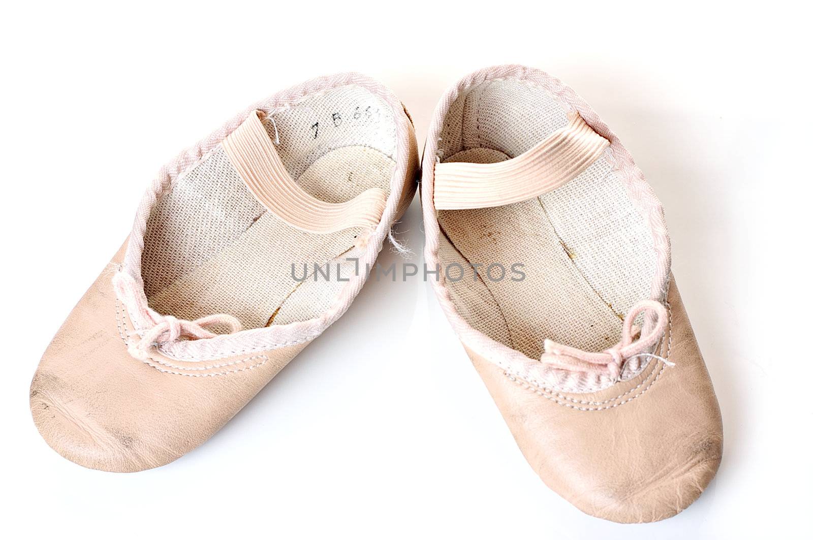 Small pink ballet shoes on a white background