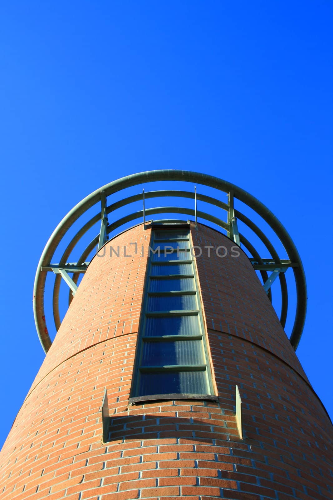 Close up of a tall tower over blue sky.
