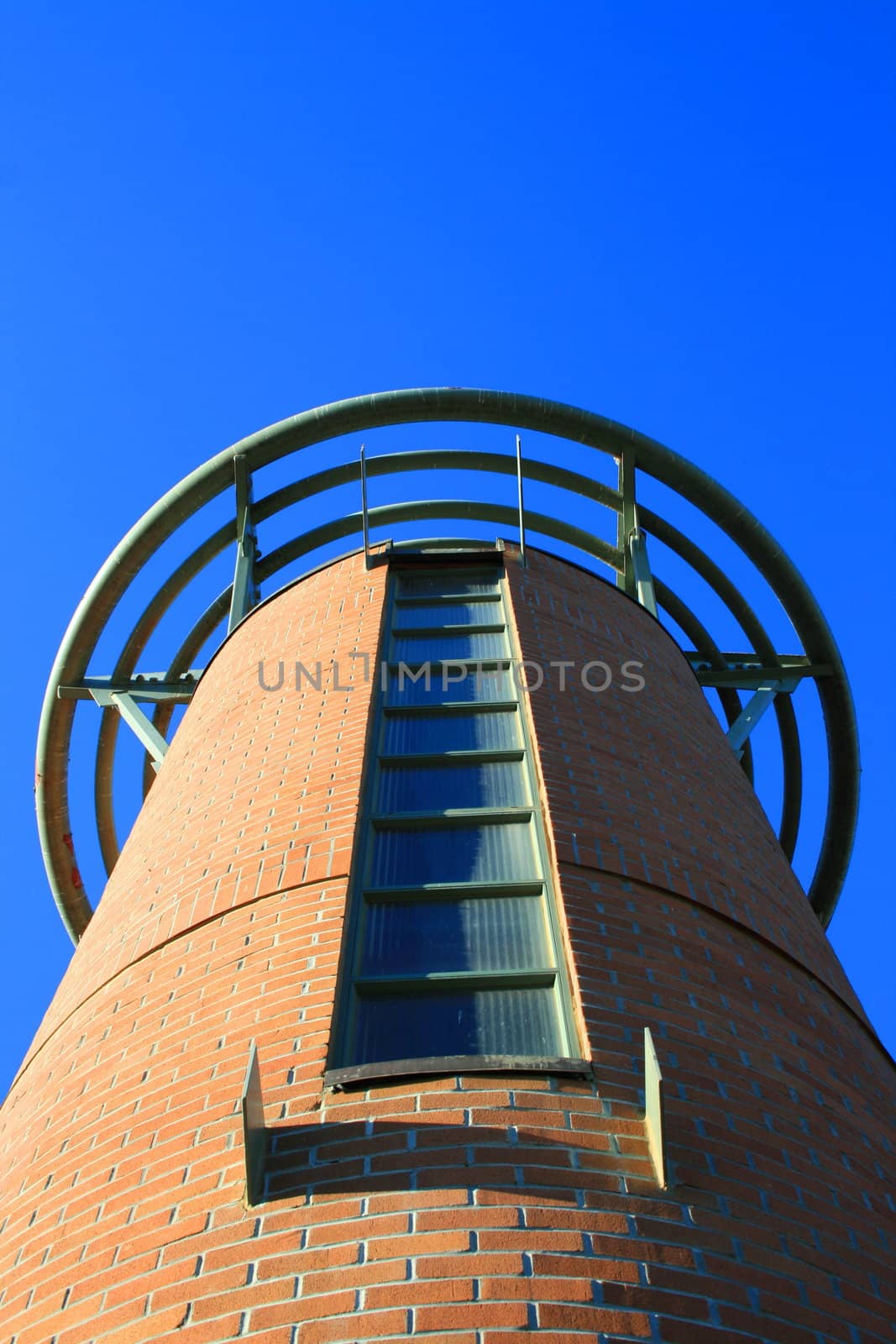 Close up of a tall tower over blue sky.
