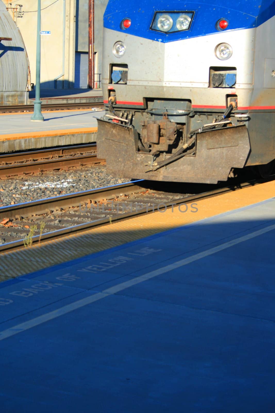 Passenger train parked at a train yard.
