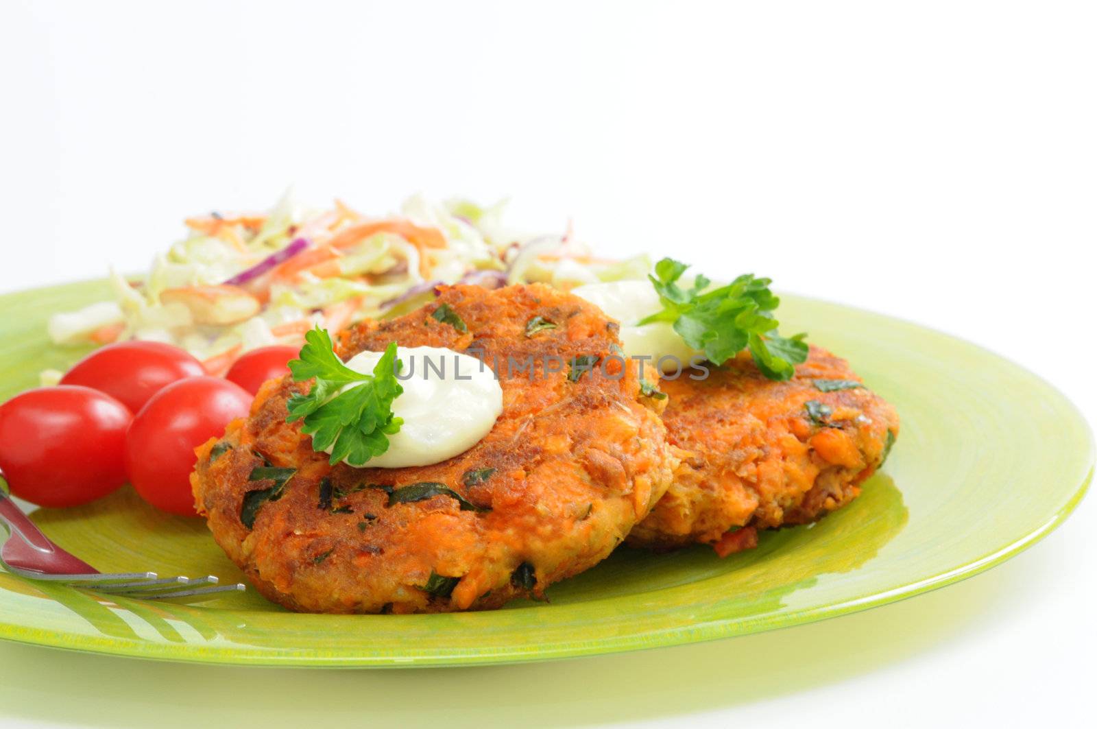 Fresh homemade salmon cakes served with vegetables.